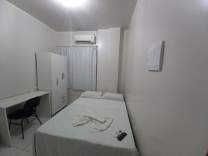 Habitación blanca con cama, escritorio y ordenador en Hamara Soft Hotel 1, en Altamira