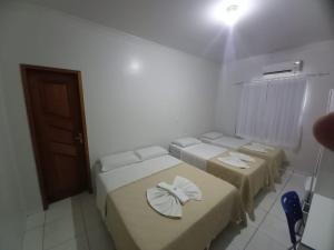 a room with three beds with towels on them at Hamara Soft Hotel 1 in Altamira