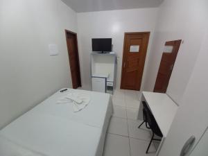 Camera bianca con scrivania e TV di Hamara Soft Hotel 1 ad Altamira
