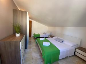 um quarto com uma cama grande e um cobertor verde em Apartments Ori em Pula