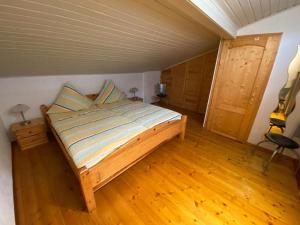 um quarto com uma cama e piso em madeira em Ferienhaus Jüngling em Wimbach