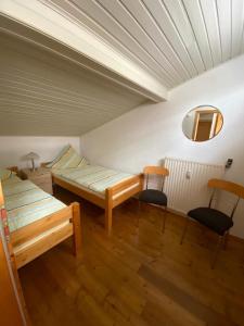 Habitación con 2 camas y 2 sillas. en Ferienhaus Jüngling, en Wimbach