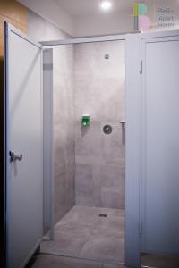 W łazience znajduje się prysznic ze szklanymi drzwiami. w obiekcie Kapsuły Bello ApartHostel w Warszawie