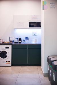 a kitchen with a stove and a washing machine at Kapsuły Bello ApartHostel in Warsaw