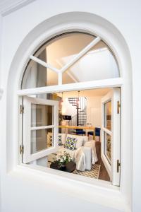 an arched window in a living room with a couch at Casa Sevilla 1920 Suites by Época in Seville