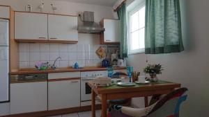 uma cozinha com uma mesa, um lavatório e um fogão em Ostseeblick em Insel Poel