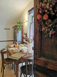 einen Esstisch mit Blumen darüber in der Unterkunft Alla Torre del Barbarossa B&B FORESTERIA in Mandello del Lario