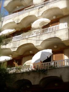 a building with white umbrellas on a balcony at Eleni's Rooms in Loutra Edipsou