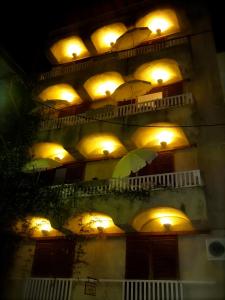 a building with yellow lights and a green umbrella at Eleni's Rooms in Loutra Edipsou