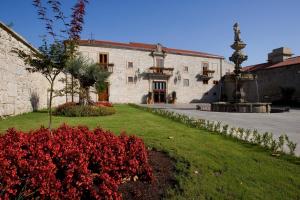 ein großes Steingebäude mit einem Brunnen im Hof in der Unterkunft Hotel Pazo de Lestrove by Pousadas de Compostela in Padrón