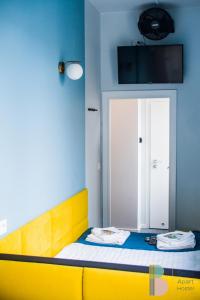 a bedroom with a yellow bed and a blue wall at Kapsuły Bello ApartHostel in Warsaw