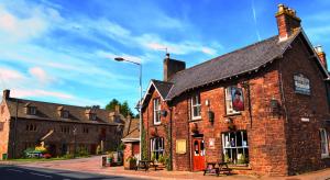 un edificio de ladrillo al lado de una calle en The George Inn & Millingbrook Lodge Ltd, en Lydney