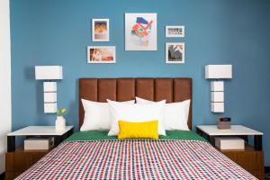 um quarto com paredes azuis e uma cama com uma almofada amarela em Uptown Suites Extended Stay Charlotte NC - Concord em Concord