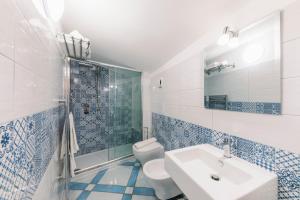 a blue and white bathroom with a sink and a toilet at A casa di Nonna Marianna in Ravello