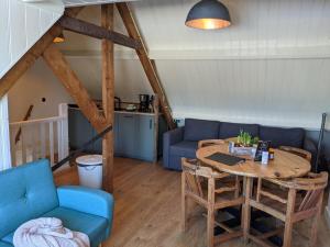a living room with a table and a blue couch at CRASH'NSTAY - Weidezicht in Sprang-Capelle