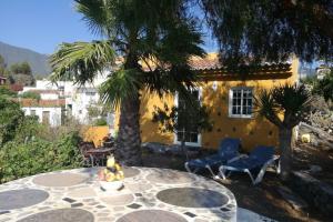 une terrasse avec une table et des chaises ainsi qu'une maison jaune dans l'établissement Casa Las Laderitas B, à El Paso