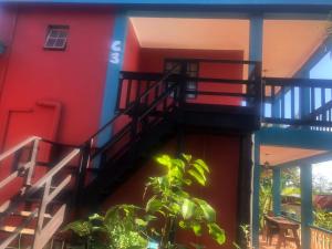 a red building with stairs on the side of it at Tri M Waves Lodge in Ponta do Ouro