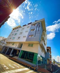 un edificio alto y blanco con el sol en el cielo en Hotel Buena Vista Express, en Bucaramanga