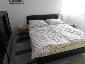 ein Bett mit einer weißen Bettdecke und zwei Kissen in der Unterkunft Haus Fermate in Wilhelmsfeld