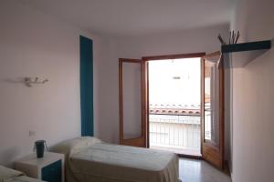 a bedroom with a bed and a large window at Hostal San Carlos in Lloret de Mar