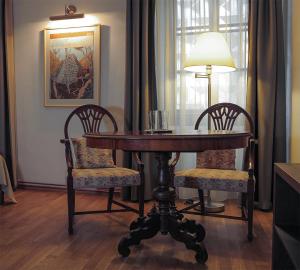 a dining room table with two chairs and a lamp at Penzion THIR in Tábor