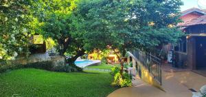 einen Hof mit einem Baum und einem Pool in der Unterkunft Hotel Chalés Gramado in Águas de Santa Barbara