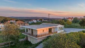Villa windmill Near Shipwreck Beach by "elite" في Volímai: منزل على تلة مع غروب الشمس في الخلفية +19 صورة