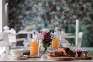 a table with a vase of flowers and orange juice at 123 MAINSTREET boutique hotel in St Julian's