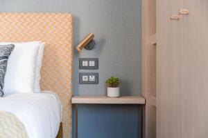 een slaapkamer met een bed en een tafel met een plant erop bij 123 MAINSTREET boutique hotel in St Julian's