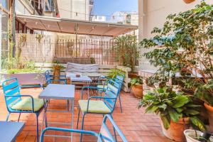 un patio al aire libre con mesas, sillas y plantas en Factory Suites Barcelona, en Barcelona