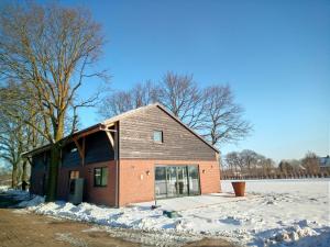 a house with snow on the ground in front of it at B&B In de Wei in Erp