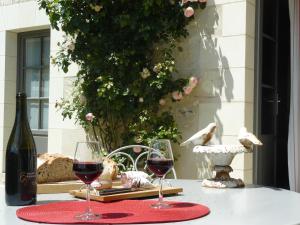 twee glazen rode wijn zittend op een tafel bij Chambres d'Hôtes Rue du Poids in Bourgueil