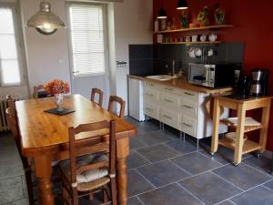a kitchen with a wooden table and a microwave at Chambres d'hôtes Rue du Poids in Bourgueil