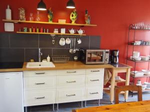 a kitchen with a sink and a counter with a microwave at Chambres d'hôtes Rue du Poids in Bourgueil
