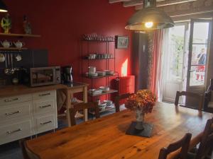 a kitchen with a wooden table with a vase of flowers on it at Chambres d'hôtes Rue du Poids in Bourgueil +2 photos