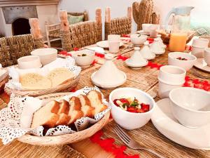 una mesa con pan y tazones de comida. en Riad Gasämbre Touareg, en Marrakech