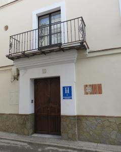 - un bâtiment avec une porte en bois et un balcon dans l'établissement Casa de las Especias Hotel Boutique, à Sanlúcar de Barrameda