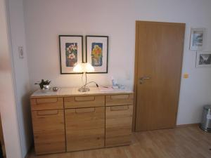 a lamp on top of a wooden dresser in a room at Ferienwohnung Luzia in Nettetal