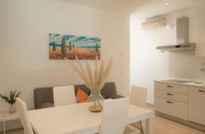 a white kitchen with a white table and chairs at I SUONI DEL MARE in Porto San Giorgio