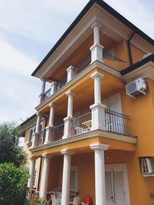 a large yellow building with a balcony on it at Villa Dubravka in Lopar