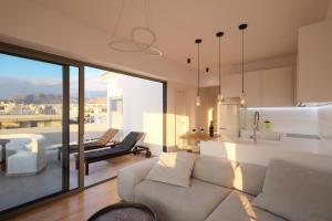 ein Wohnzimmer mit einem weißen Sofa und einer Küche in der Unterkunft Amazing Suite at Glyfada with sea view & jacuzzi in Athen