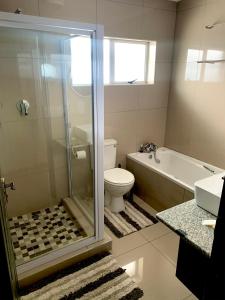 a bathroom with a shower and a toilet and a sink at Estee House in Newcastle