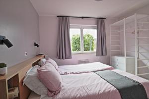 een slaapkamer met 2 bedden en een raam bij Maison Violette in Durbuy