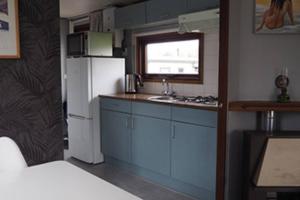 a kitchen with blue cabinets and a white refrigerator at Vakantiehuisje Makkum NL - S15 in Makkum