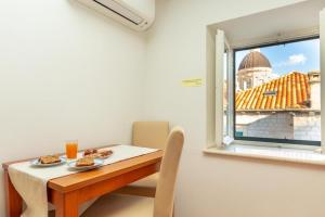 een tafel met twee borden eten en een raam bij APARTMENT PLACA DUBROVNIK 2 in Dubrovnik