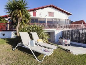 a white chair sitting on the grass in front of a house at Maison Bista Eder in Bidart