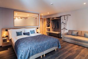 a bedroom with a large bed and a couch at Hotel Edelweiss Superior in Mürren