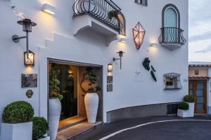 eine weiße Fassade eines Gebäudes mit Treppen und Pflanzen in der Unterkunft Hotel Villa Franca in Positano
