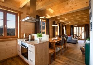 eine Küche und ein Esszimmer in einem Blockhaus in der Unterkunft Arlitscherhof Ferienwohnungen und Chalets in Bad Eisenkappel