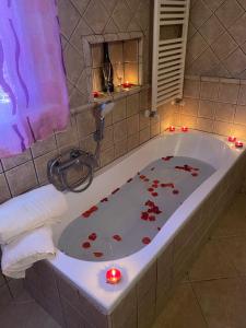 uma casa de banho com uma banheira com velas vermelhas em Residenza Nosy Be em Palombara Sabina